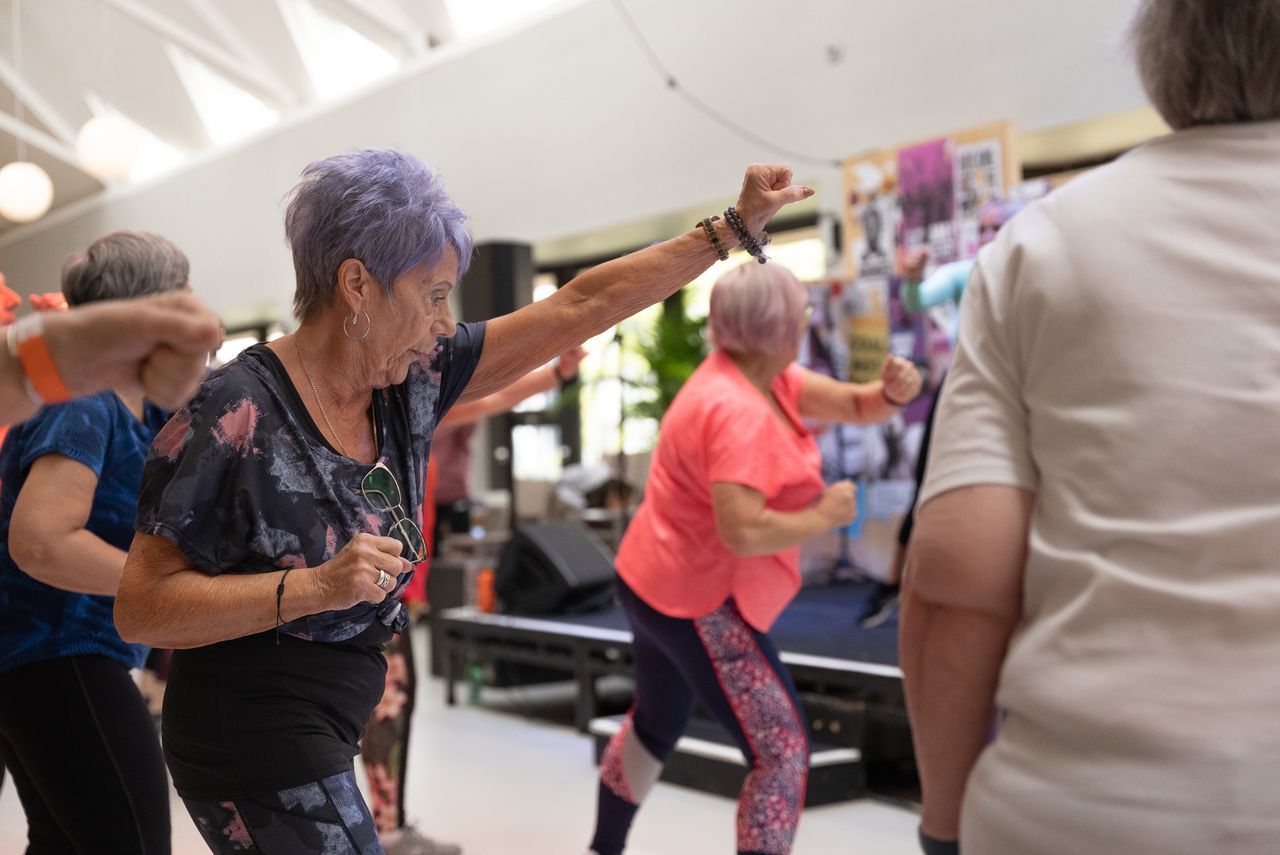 Group of senior women engaged in fitness activities indoors, promoting healthy aging.